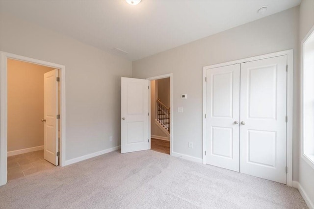 unfurnished bedroom with carpet flooring, baseboards, and a closet