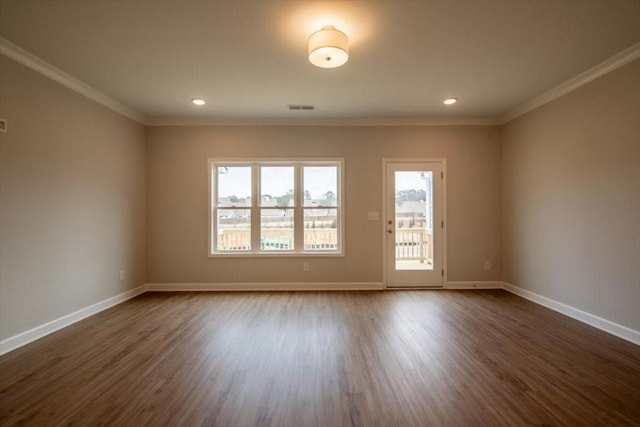 spare room featuring visible vents, baseboards, dark wood finished floors, and crown molding