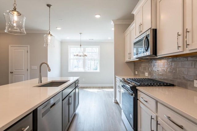 kitchen with crown molding, backsplash, appliances with stainless steel finishes, and a sink