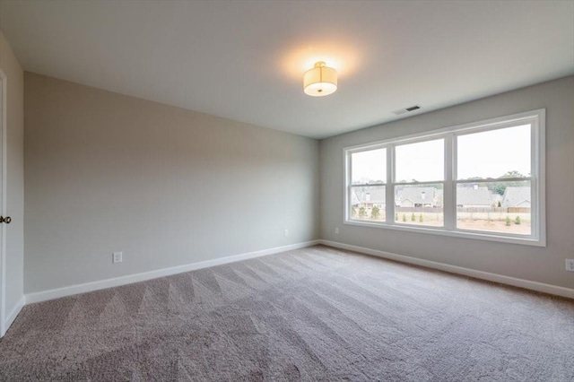 unfurnished room featuring visible vents, carpet, and baseboards