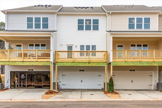 view of front of property featuring cooling unit, a garage, and driveway