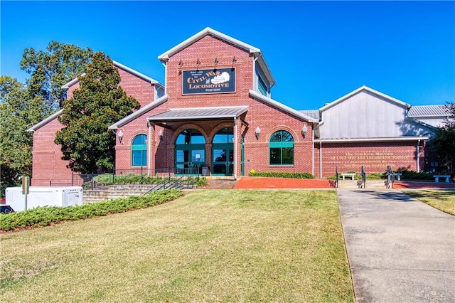 view of front of house featuring brick siding and a front yard