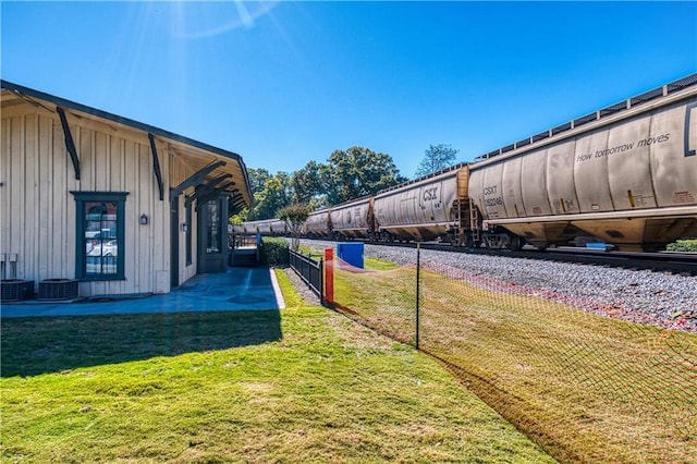 view of yard featuring central air condition unit and fence