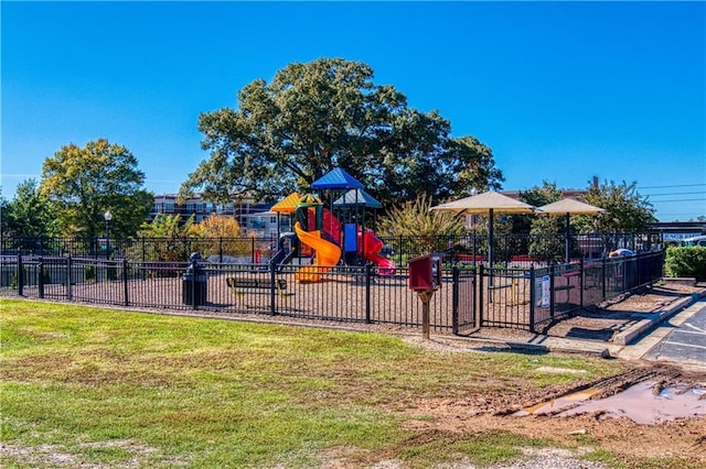 community jungle gym featuring fence and a lawn