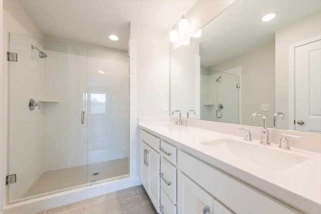 bathroom featuring double vanity, recessed lighting, a stall shower, and a sink