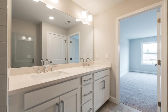 bathroom featuring double vanity, visible vents, baseboards, and a sink