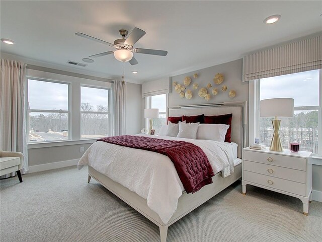 carpeted bedroom featuring ceiling fan and multiple windows