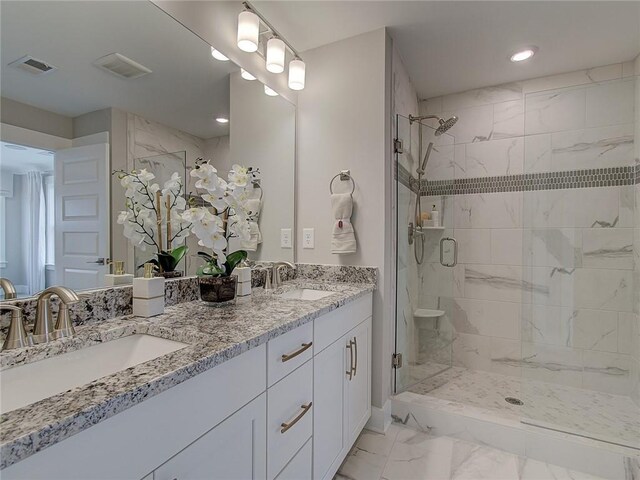 bathroom featuring tile patterned flooring, double vanity, and a shower with door