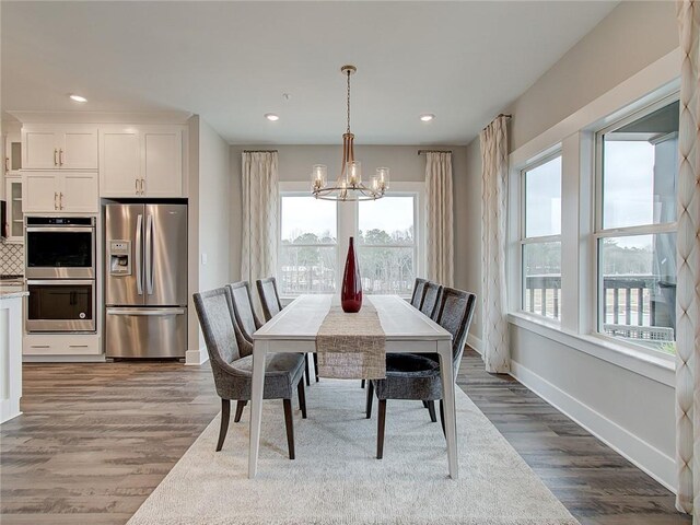 dining space featuring plenty of natural light, hardwood / wood-style floors, and a chandelier