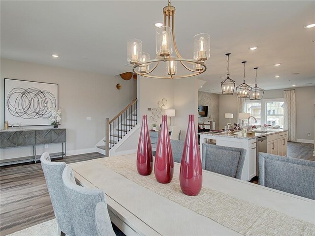 dining area featuring sink, a notable chandelier, and wood-type flooring