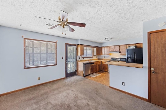 kitchen with light carpet, sink, ceiling fan, kitchen peninsula, and stainless steel appliances