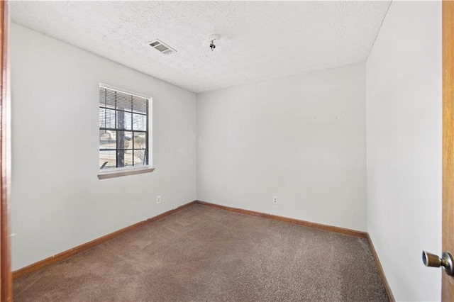 empty room featuring a textured ceiling and carpet floors