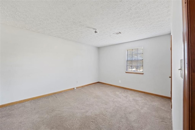 carpeted empty room with a textured ceiling