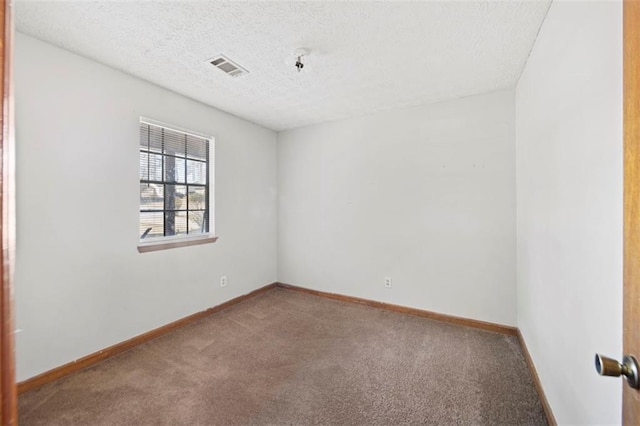 spare room featuring carpet flooring and a textured ceiling