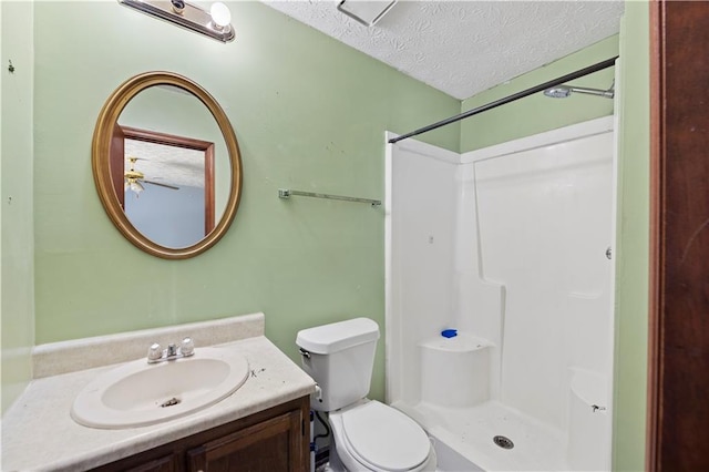 bathroom featuring a shower, vanity, a textured ceiling, and toilet