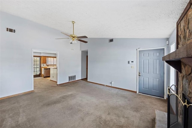 unfurnished living room with vaulted ceiling, light colored carpet, a stone fireplace, and ceiling fan