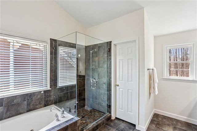 bathroom with baseboards, a stall shower, and a bath