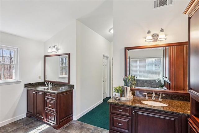 bathroom featuring visible vents, baseboards, vanity, and vaulted ceiling