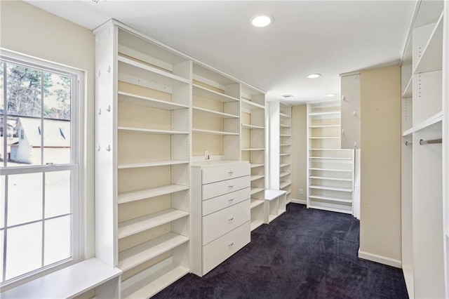 walk in closet featuring dark colored carpet