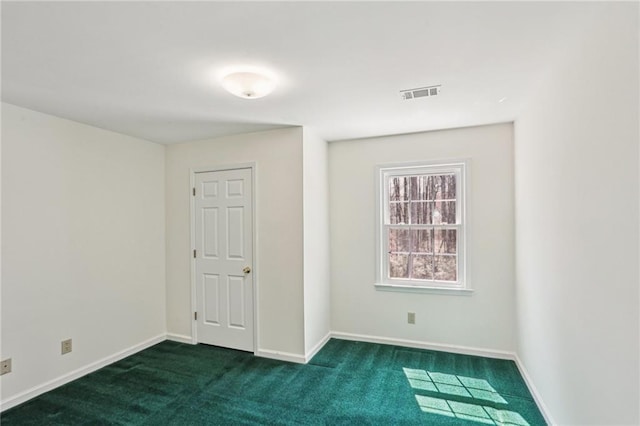 carpeted spare room with visible vents and baseboards