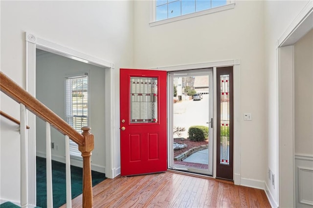 foyer entrance featuring stairway, baseboards, and wood-type flooring