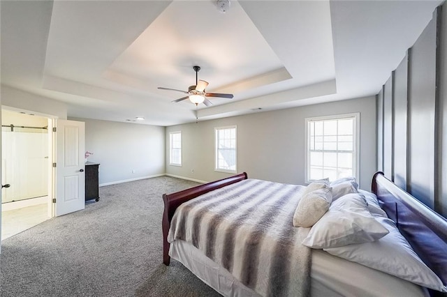 bedroom with ceiling fan, a raised ceiling, and carpet flooring