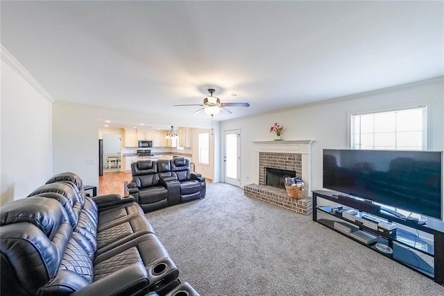 living room with a fireplace, ceiling fan, crown molding, and carpet floors