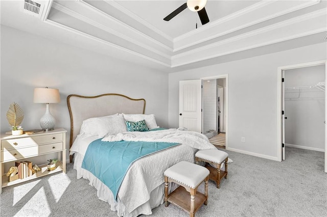 carpeted bedroom with a spacious closet, ceiling fan, a closet, and a tray ceiling