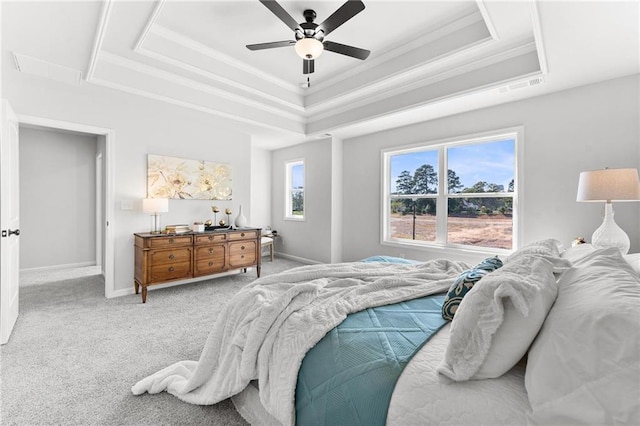 carpeted bedroom featuring a tray ceiling and ceiling fan