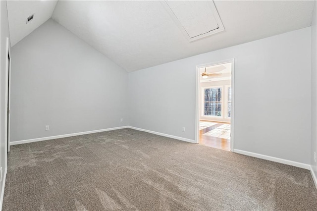 spare room featuring carpet floors, vaulted ceiling, and ceiling fan