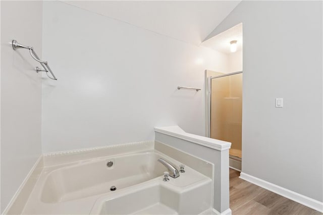 bathroom featuring hardwood / wood-style floors, lofted ceiling, and shower with separate bathtub