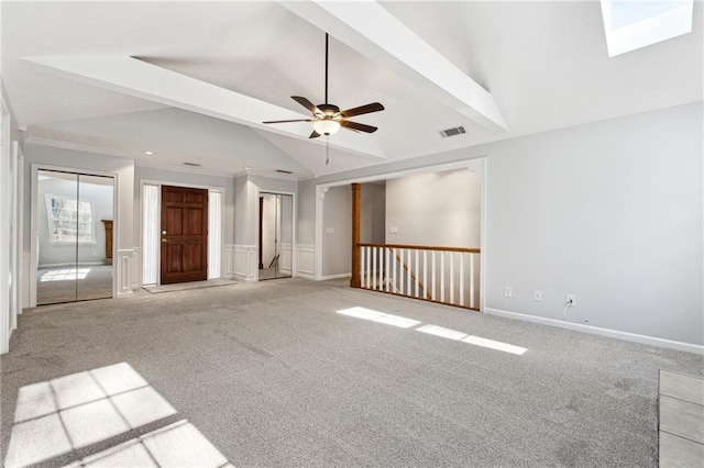 carpeted spare room featuring ceiling fan and lofted ceiling with beams