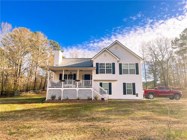 split level home featuring a porch, a chimney, and a front lawn