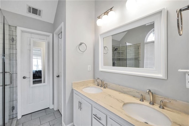 bathroom with double vanity, visible vents, a shower stall, and a sink