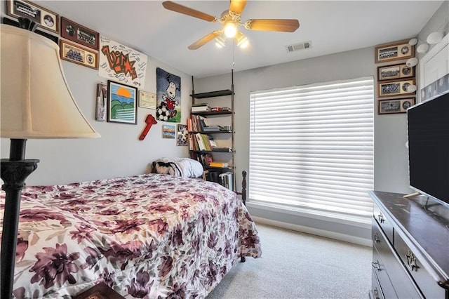 carpeted bedroom with visible vents, a ceiling fan, and baseboards