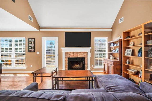 living room featuring visible vents, a fireplace, and vaulted ceiling