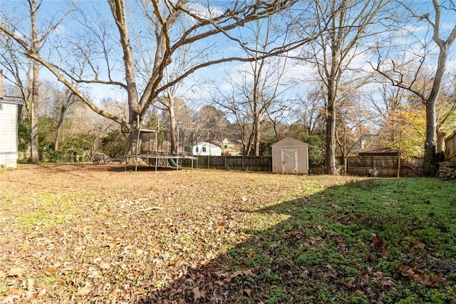 view of yard featuring a storage shed and a trampoline