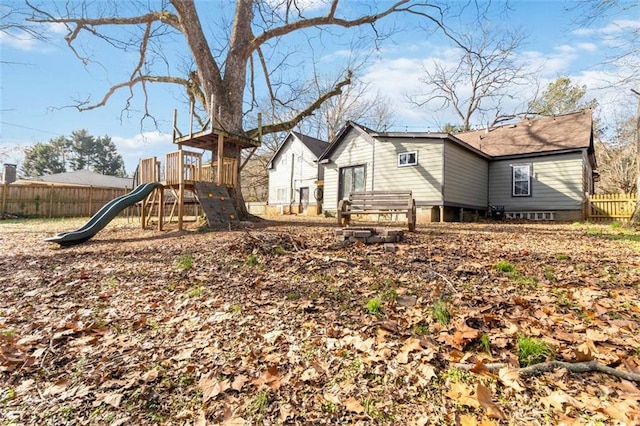 rear view of house featuring a playground