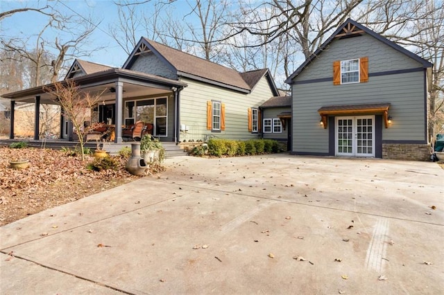 rear view of property with french doors and a porch