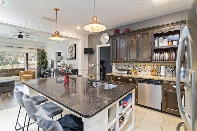 kitchen featuring dark brown cabinetry, sink, hanging light fixtures, a kitchen breakfast bar, and appliances with stainless steel finishes