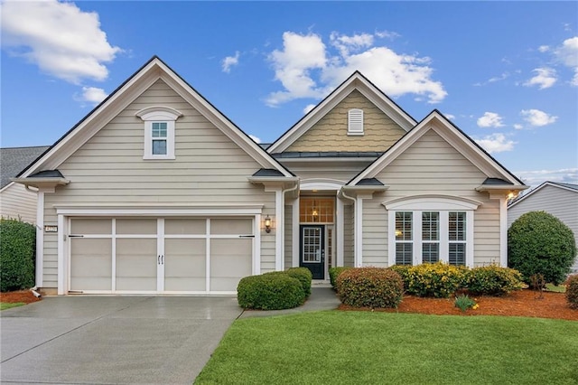 view of front of house featuring a garage, concrete driveway, and a front lawn