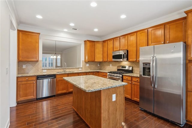 kitchen with dark wood-type flooring, brown cabinets, appliances with stainless steel finishes, and a sink