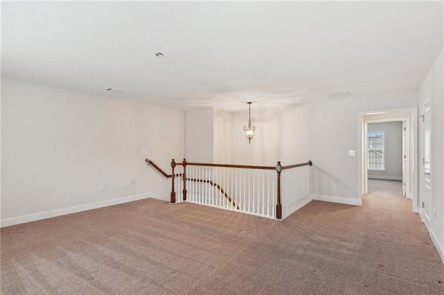 carpeted spare room featuring baseboards