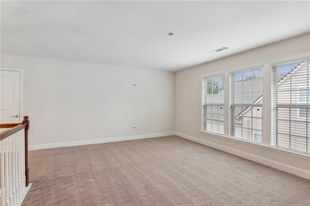 unfurnished room featuring light carpet, visible vents, and baseboards