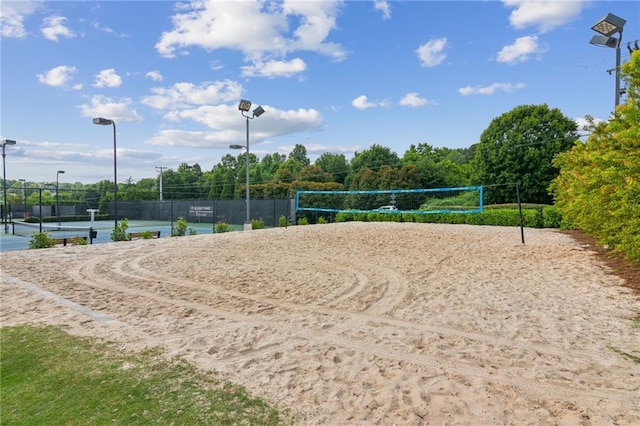 view of property's community featuring volleyball court, a tennis court, and fence