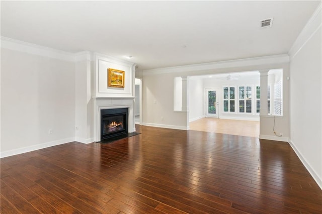 unfurnished living room with visible vents, ornate columns, a fireplace, ornamental molding, and wood-type flooring