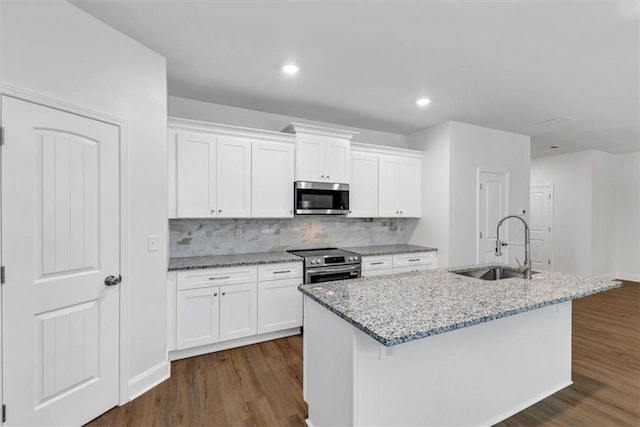 kitchen featuring white cabinets, stainless steel appliances, dark wood finished floors, and a sink