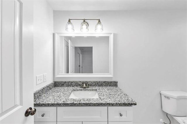 half bathroom featuring vanity and toilet