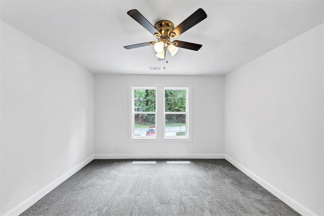 carpeted spare room with baseboards, a ceiling fan, and visible vents