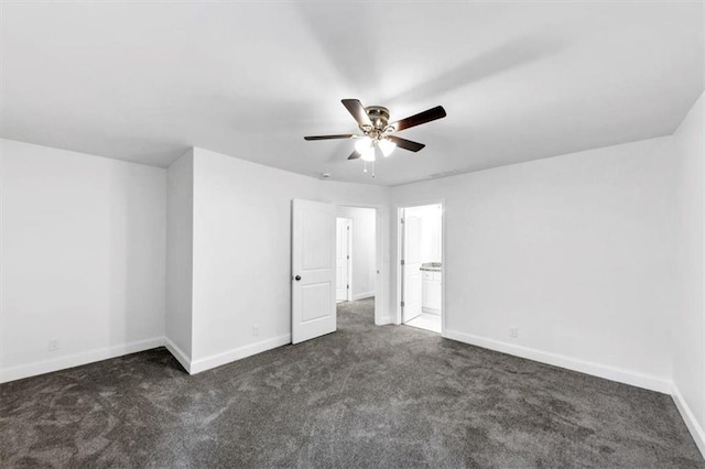 unfurnished bedroom with dark carpet and baseboards